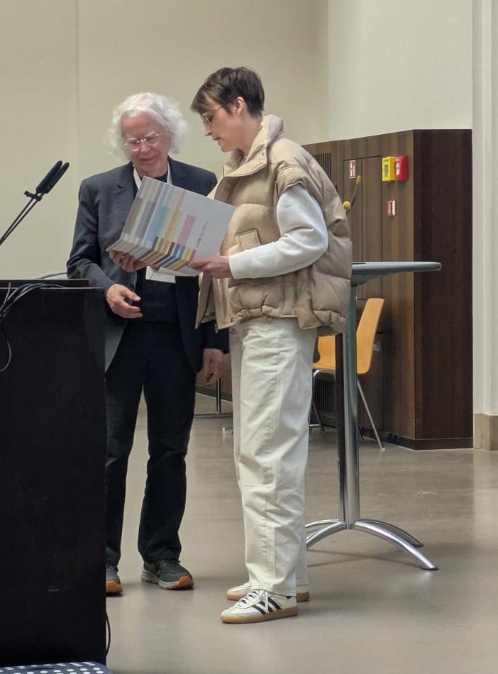 Sandra Hofhues überreicht Stefan Aufenanger eine Urkunde. 